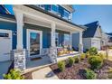 Inviting front porch with stone pillars and cozy seating area, perfect for relaxing at 1986 Thoreau Way, York, SC 29745