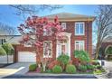Attractive brick home featuring manicured landscaping, a red maple tree, and an attached two-car garage at 2021 Nolen Park Ln, Charlotte, NC 28209