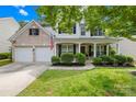 Inviting two-story home with a brick and siding facade, a two-car garage, and a welcoming front porch with manicured landscaping at 20827 Brinkley St, Cornelius, NC 28031