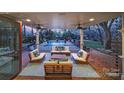 Gorgeous covered patio with ceiling fans and elegant outdoor seating overlooks the pool at 2132 Rolston Dr, Charlotte, NC 28207