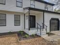 Inviting front porch with black railings and steps leading to a black front door at 4427 Gaynelle Dr, Charlotte, NC 28215