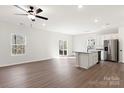 Open floor plan with stainless steel appliances, modern white cabinets, granite countertops, and wood-look floors at 507 Maddox Dr, Shelby, NC 28152