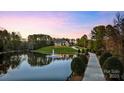Picturesque view of estate home reflected in serene pond with fountain feature at 525 Lake Lynn Rd, Concord, NC 28025