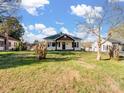 Exterior showcasing the home's facade, yard, and surrounding landscape under a partly cloudy sky at 703 Rankin Ave, Mount Holly, NC 28120