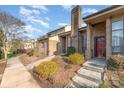 Well-kept brick townhome exterior showing a pathway, neat landscaping, and a welcoming entrance at 8033 Charter Oak Ln, Charlotte, NC 28226
