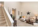 Cozy living room featuring high ceilings, staircase, comfortable seating, and neutral decor at 8033 Charter Oak Ln, Charlotte, NC 28226