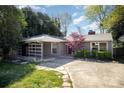 Charming home with a red chimney and covered patio, surrounded by lush greenery at 842 E Woodlawn Rd, Charlotte, NC 28209