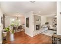 Open-concept living room with hardwood floors, brick fireplace and an adjacent dining area at 842 E Woodlawn Rd, Charlotte, NC 28209