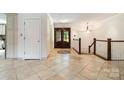 Bright foyer showcasing tile flooring, staircase, and a stylish, decorative doorway at 9500 Windygap Rd, Charlotte, NC 28278