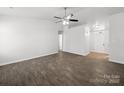 A large living room featuring a modern ceiling fan and dark wood-look floors at 10031 Orchard Grass Ct, Charlotte, NC 28278