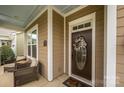Cozy front porch featuring rocking chairs, decorative door, and craftsman trim accents at 1022 Bimelech Dr, Indian Trail, NC 28079