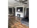 Spacious living room with fireplace, flat-screen TV, ceiling fan, and beautiful wood floors at 1022 Parker St, Monroe, NC 28112