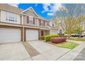 Attractive townhome featuring a single car garage, red shutters, and a well-manicured front yard at 11308 Morgan Valley Ln, Charlotte, NC 28270