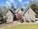 Beautiful brick home with manicured lawn, mature landscaping, and solar panels on a sunny day at 124 Cedar Woods Dr, Mooresville, NC 28117