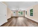 Bright living room with tan walls, wood-look floors, and natural light from three large windows at 1587 Green Circle Dr, Gastonia, NC 28054