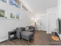 Cozy living room with a modern sectional couch, hardwood floors, and ample natural light from large windows at 2403 Earley Cir, Kannapolis, NC 28083