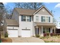Charming two-story home with two-car garage, light siding, blue shutters and well-maintained landscaping at 4006 Stockbrook Dr, Charlotte, NC 28215