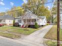 Traditional-style home with white siding, front porch and a long driveway at 405 E 3Rd St, Kannapolis, NC 28083
