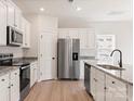 Bright kitchen featuring stainless steel appliances, granite countertops, and sleek white cabinetry at 508 Maddox Dr, Shelby, NC 28152