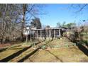 View of the screened in back porch, garden, and spacious backyard of this home at 544 Stoneybrook Rd, Statesville, NC 28677