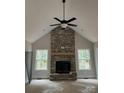 Cozy living room featuring a floor-to-ceiling stone fireplace and a ceiling fan at 5947 Tipperary Dr, Denver, NC 28037