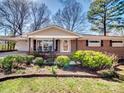 Classic brick home with a cozy front porch and lush landscaping at 601 Wilmar Nw St, Concord, NC 28025