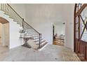 Grand foyer with tile floors, staircase with iron railing, and view into the home office at 7295 Three Sisters Ln, Concord, NC 28027