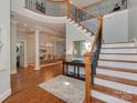Grand foyer featuring hardwood floors, a staircase with iron railings, and an open view into the dining room at 8015 Greenview Terrace Ct, Charlotte, NC 28277