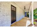 Inviting front porch featuring wooden floors, brick walls, a hanging lantern, and ample space at 1132 E Main St, Albemarle, NC 28001