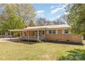 Charming single-story home featuring a covered porch overlooking a spacious backyard and landscaped greenery at 1747 Williams Cir, Lancaster, SC 29720