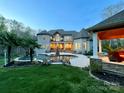 Twilight view of backyard featuring a luxurious pool, landscaped gardens, and elegant home exterior at 2017 Colorado Ct, Lancaster, SC 29720