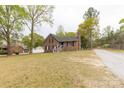 Well-manicured lawn leads up to a brick home that features a black front door and crisp, white railing at 2220 Ross Cauthen Rd, Lancaster, SC 29720