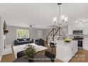 Open-concept living space with modern furnishings, white kitchen, island, and staircase at 2220 Ross Cauthen Rd, Lancaster, SC 29720