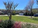 Exterior shot of home and yard, framed by spring trees at 353 Montibello Dr, Mooresville, NC 28117