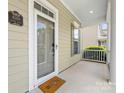 Covered front porch showcasing the home's address plaque, a 'Welcome' mat, and view of the neighborhood at 4148 Cedar Point Ave, Matthews, NC 28104