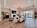 Spacious living room with fireplace, hardwood floors, recessed lighting, and balcony access at 19329 Watermark Dr # 142, Cornelius, NC 28031