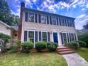 Charming two-story home with dark shutters, blue door, brick steps, and manicured landscaping at 443 Silversmith Ln, Charlotte, NC 28270