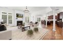 Open-concept living room with fireplace, hardwood floors, and views into the kitchen area at 7605 Berryfield Ct, Waxhaw, NC 28173