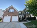 Charming two-story brick home featuring a two-car garage and well-maintained landscaping at 7925 Woodmere Dr, Harrisburg, NC 28075