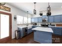 Charming kitchen with blue cabinets, stainless steel appliances, and a farmhouse sink at 4519 S Potter Rd, Monroe, NC 28112