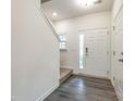 Bright foyer with light gray flooring and a white door with glass panel, next to carpeted stairs at 558 Dulaney Dr, Fort Mill, SC 29708