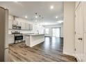 An open-concept kitchen features stainless steel appliances, gray cabinets, and an island with bar seating at 558 Dulaney Dr, Fort Mill, SC 29708