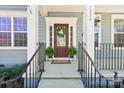Inviting front entrance featuring a red door with glass, decorative wreath, and black metal railing at 1034 Currituck Way, York, SC 29745