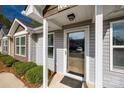 Welcoming entrance featuring a modern glass storm door and landscaped surroundings at 104 S Canyon Rdg, Mount Holly, NC 28120