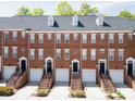 Brick townhome exteriors in a row, displaying stoops and garages beneath dormer windows and dark roofing at 1122 Dean Hall Ln, Matthews, NC 28105