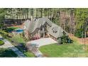 Expansive property featuring a beautiful pool, lush landscaping, and a stately home at 115 Stonewall Beach Ln, Mooresville, NC 28117