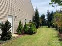 Spacious backyard featuring manicured lawn, mature trees, and privacy fence at 116 Water Ski Dr, Statesville, NC 28677