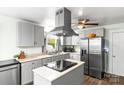Well-lit kitchen boasts stainless steel appliances, a center island, and ample cabinet space at 1301 Jackson St, Kannapolis, NC 28083