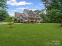 Charming two-story home with a stone facade, inviting front porch, and manicured lawn at 217 Blossom Hill Rd, Lincolnton, NC 28092