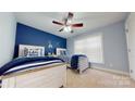 Charming bedroom with two twin beds, nautical decor, a ceiling fan, and natural light from the window at 22970 Lake Tillery Rd, Albemarle, NC 28001